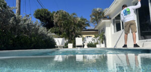 Benefits of professional pool maintenance- pool technician performing routine maintenance