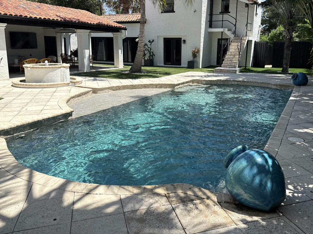 Modern residential pool renovation featuring updated tile, coping, and water features