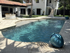 Modern residential pool renovation featuring updated tile, coping, and water features