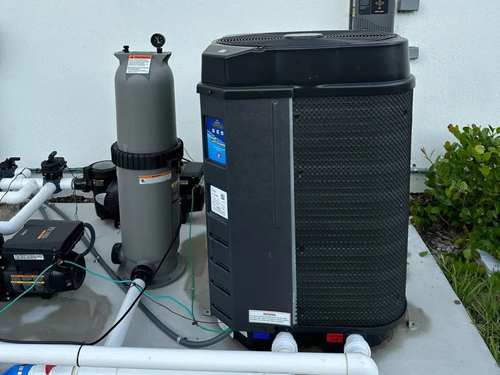 Pool heat pump installed on residential pool equipment pad in Palm Beach County, Florida.