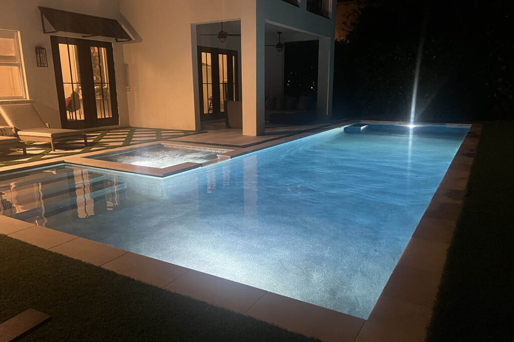 Modern residential swimming pool illuminated with LED lighting during an evening swim