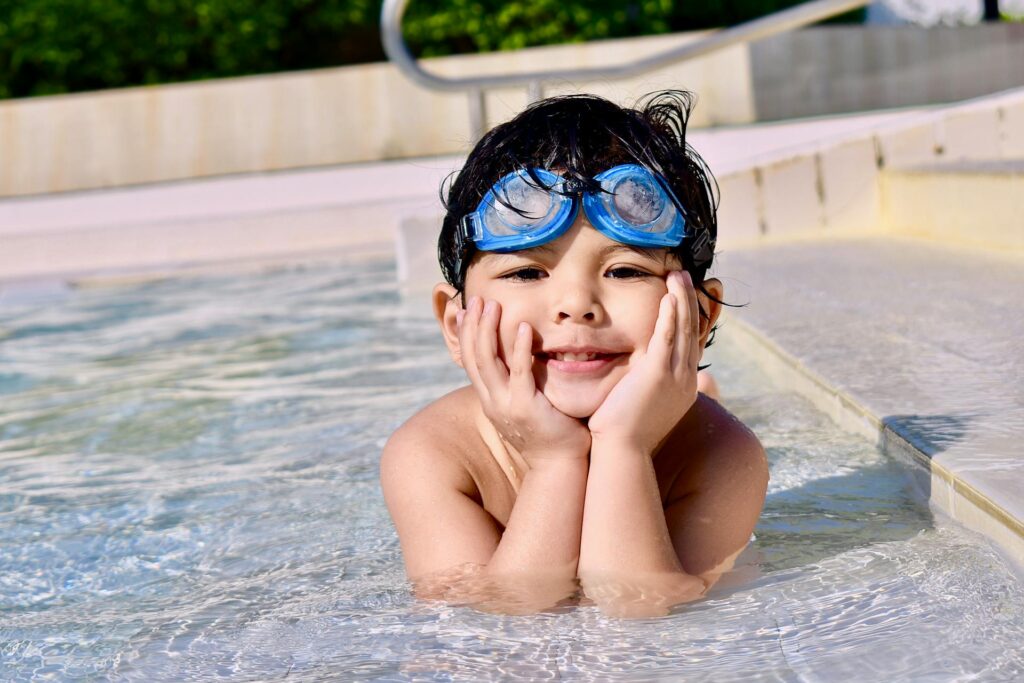 Child playing in a clean swimming pool, representing safe family pool cleaning service in Palm Beach Gardens