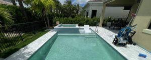 Residential pool with vacuum and test kit on deck, illustrating when to call a pool professional for expert maintenance
