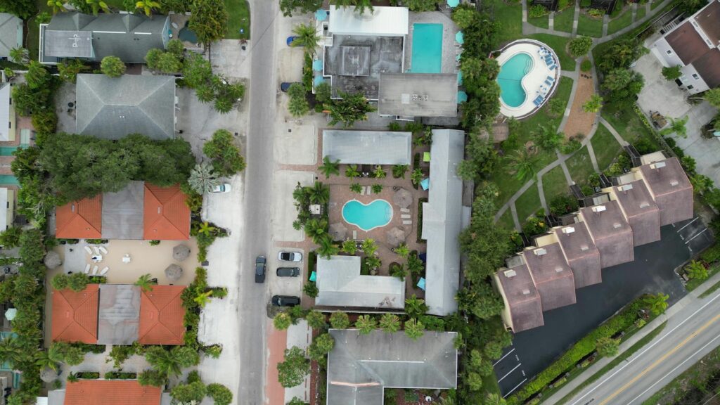Aerial view of Florida neighborhood with multiple backyard pools, illustrating how pool maintenance impacts home insurance.