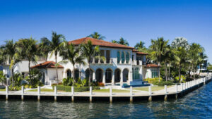 Luxurious Florida waterfront home with palm trees and a modern exterior, showcasing high-impact home improvements that enhance home value.