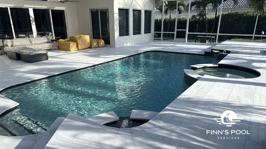 A modern in-ground pool with clean white decking and a spa, showing how outdoor upgrades can be home improvements that enhance home value.