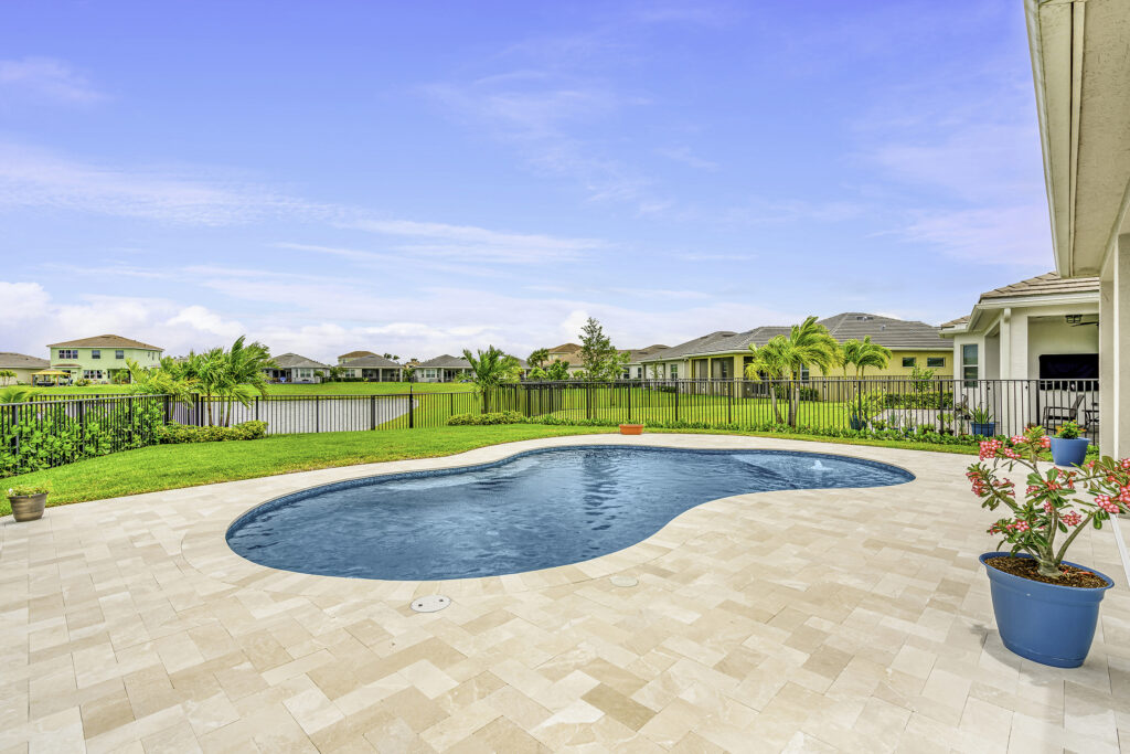 A bright Florida backyard with a swimming pool and patio, showcasing a well-designed outdoor living space in Florida.