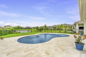 A bright Florida backyard with a swimming pool and patio, showcasing a well-designed outdoor living space in Florida.