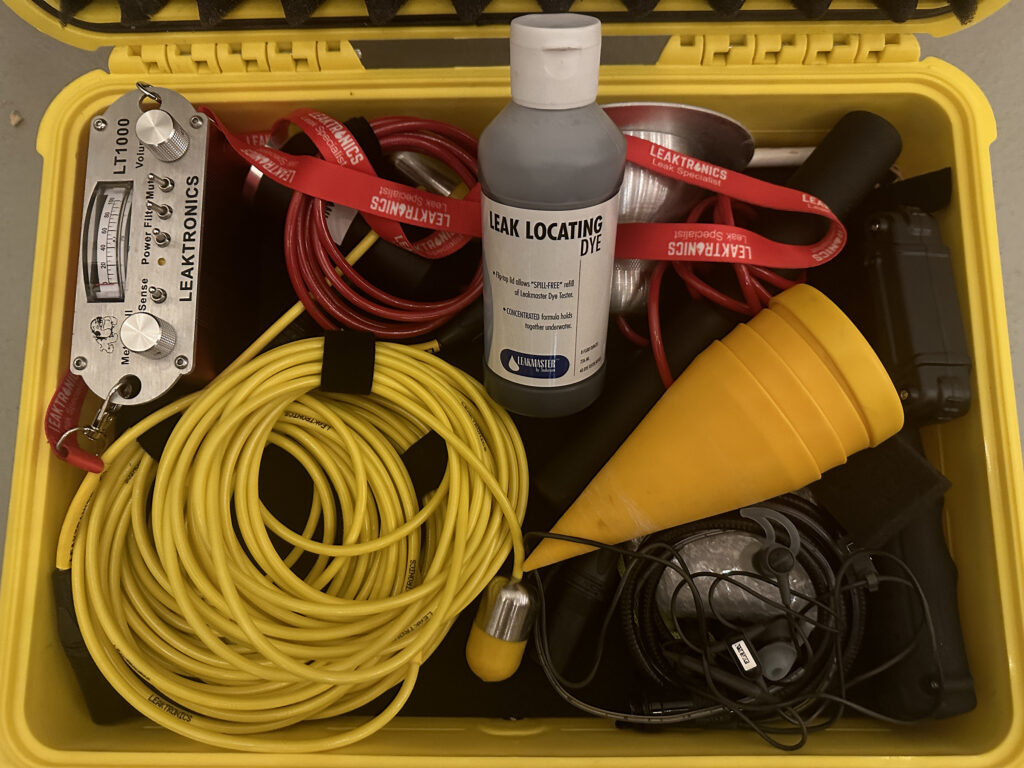 Professional equipment used for pool leak detection including electronic listening tools and dye testing