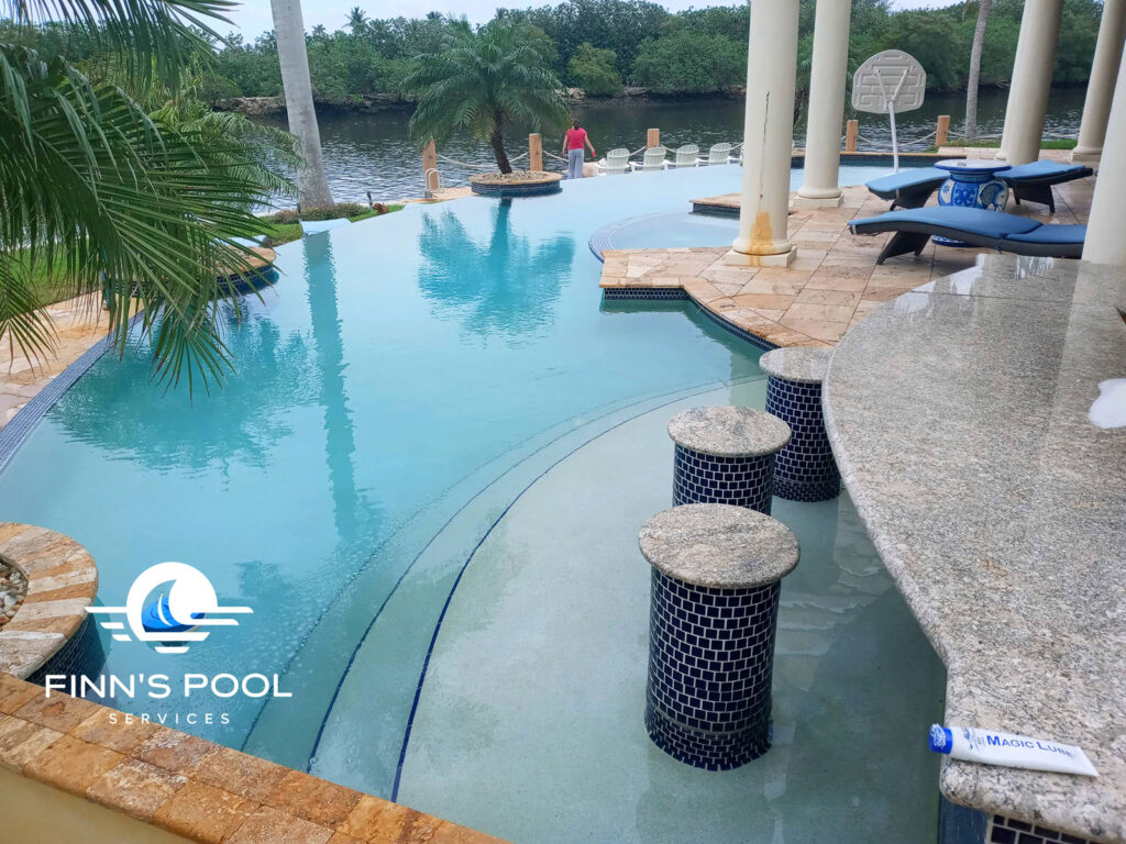 A clean, waterfront swimming pool prepared for entertaining, illustrating how to prepare your pool for guests in West Palm Beach.