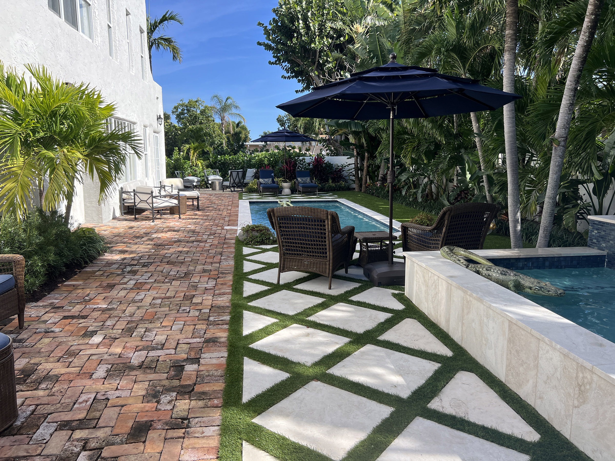 A guest-ready Florida backyard with a clean pool, seating areas, and landscaping, showing how to prepare your pool for guests in West Palm Beach.