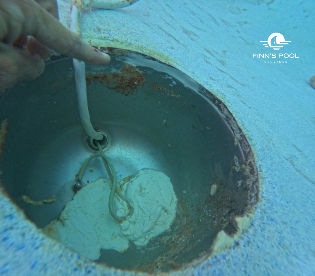 Professional pool leak detection showing a technician identifying water loss around a damaged light niche.