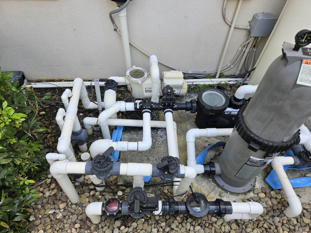 Pool equipment installation showing pumps, filters, and plumbing as hidden costs of pool construction