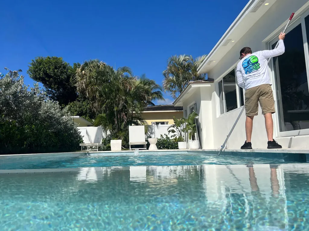 Finn's Pool Services' employee cleaning a West Palm Beach pool.
