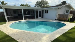 Backyard swimming pool at a South Florida home with tropical landscaping